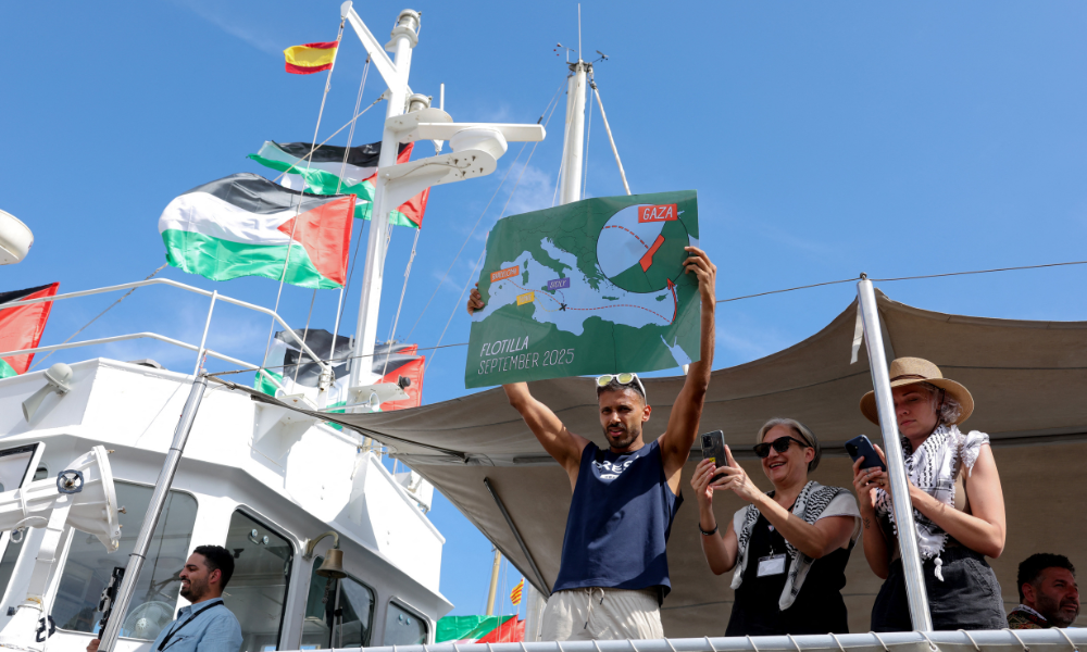 Um ativista mostra um mapa enquanto embarca em um barco, parte de uma flotilha civil que visa romper o bloqueio israelense à Faixa de Gaza, no porto de Barcelona, ​​em 31 de agosto de 2025. Uma flotilha com ajuda humanitária e ativistas deve partir de Barcelona em 31 de agosto de 2025 para tentar "romper o cerco ilegal de Gaza", disseram os organizadores. A flotilha deve chegar ao enclave costeiro devastado pela guerra em meados de setembro. (Foto de Lluis GENE / AFP)