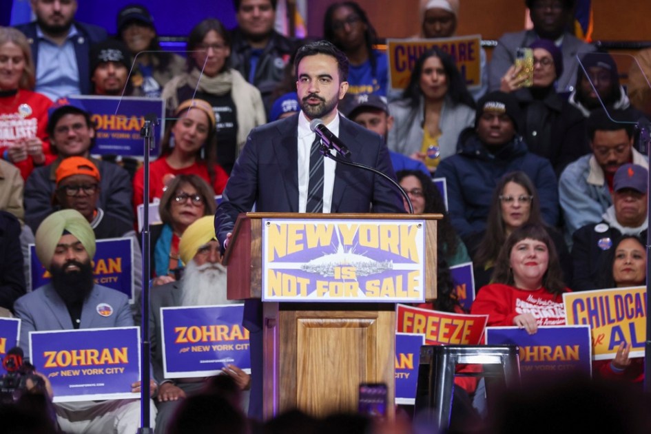O candidato democrata à prefeitura de Nova York, Zohran Mamdani (C), discursa durante o comício "Nova York Não Está à Venda" no Estádio Forest Hills, no bairro do Queens, em Nova York, EUA, em 26 de outubro de 2025. O evento, organizado pelo favorito democrata na corrida para a prefeitura de Nova York, Zohran Mamdani, contará com a presença do senador Bernie Sanders e da deputada federal Alexandria Ocasio-Cortez, às vésperas do dia da eleição para prefeito de Nova York, em 4 de novembro. (Alejandría, Nova York) EFE/EPA/SARAH YENESEL