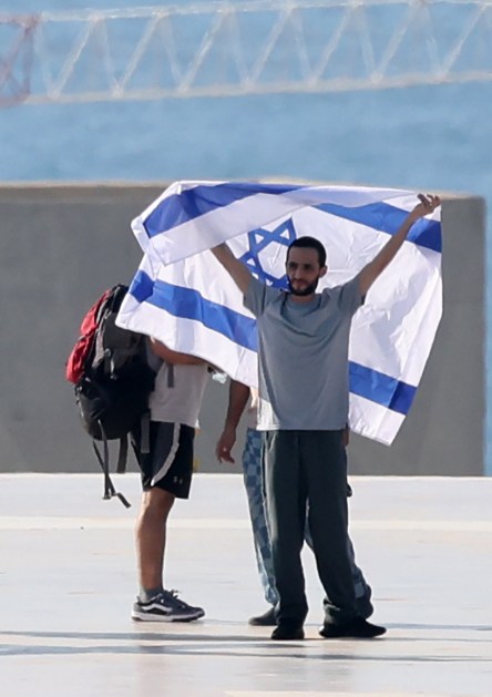 O refém israelense libertado Nimrod Cohen posa com uma bandeira israelense após chegar ao heliporto do Hospital Ichilov em Tel Aviv, Israel, em 13 de outubro de 2025. A primeira fase do acordo de paz de Gaza, firmado entre Israel e o Hamas, inclui a libertação de reféns israelenses e prisioneiros palestinos, uma retirada parcial das forças israelenses e a entrega de ajuda humanitária a Gaza EFE/EPA/ABIR SULTAN
