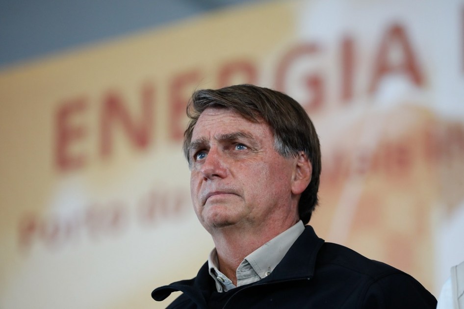 Jair Bolsonaro em frente a um banner em que a palavra energia é legível, ainda que desfocada