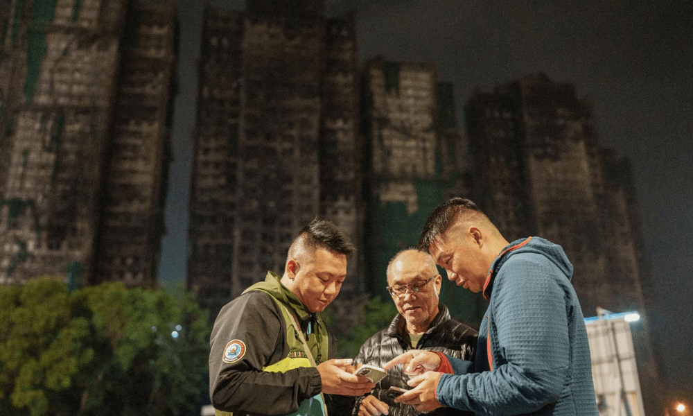 Foto mostra Yip Ka-kui (no centro) e seus filhos Yip Shun-ting e Yip Shun-yin olhando fotos antigas de sua esposa, Pak Shui-lin, enquanto relembram momentos felizes em sua casa, perto do conjunto residencial Wang Fuk Court