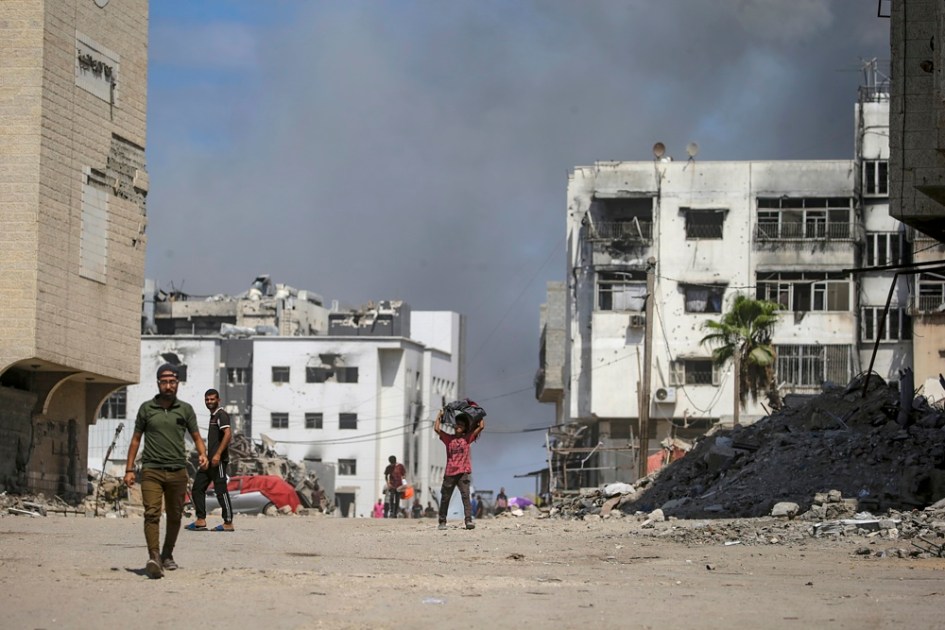 Um menino palestino (C) caminha enquanto a fumaça sobe após um ataque aéreo israelense ao redor do hospital Al-Shifa na Cidade de Gaza, Faixa de Gaza, 28 de setembro de 2025. Mais de 66.000 palestinos foram mortos na Faixa de Gaza desde outubro de 2023, de acordo com o Ministério da Saúde palestino, e cerca de 1.200 israelenses foram mortos desde o lançamento de uma campanha militar israelense em resposta a um ataque transfronteiriço do Hamas em 07 de outubro de 2023. EFE/EPA/MOHAMMED SABER