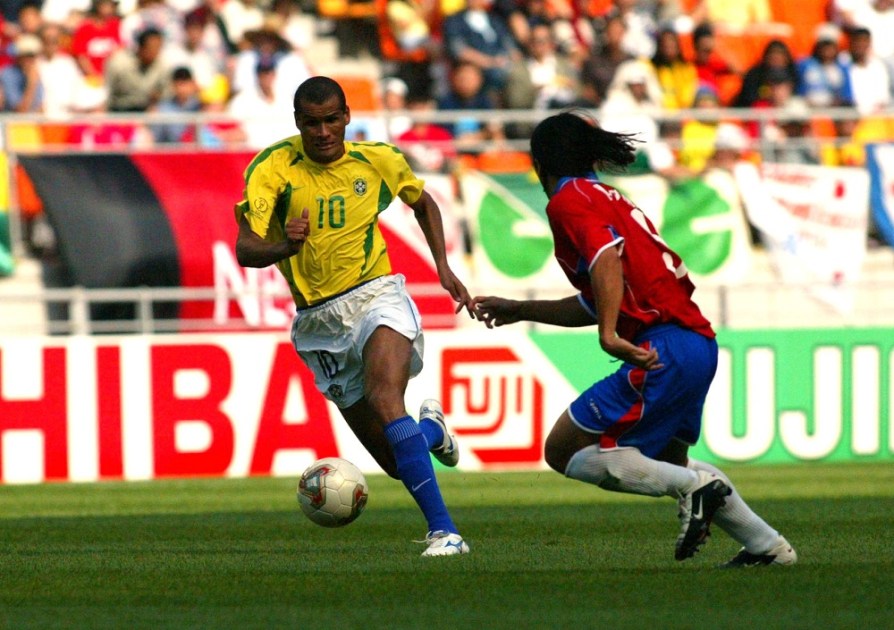 Rivaldo (esq.), atacante da Seleção Brasileira, tenta se livrar da marcação de Golberto Martinez durante jogo entre Brasil e Costa Rica, válido pela primeira fase da Copa do Mundo de 2002