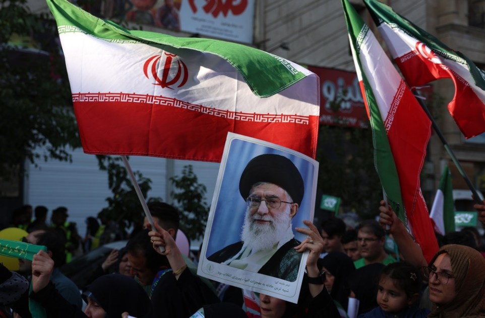 Mulher iraniana segura um cartaz com a imagem do líder supremo do Irã, aiatolá Ali Khamenei