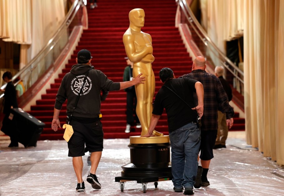 Trabalhadores transportam uma estátua do Oscar no tapete vermelho durante os preparativos para a 97ª cerimônia