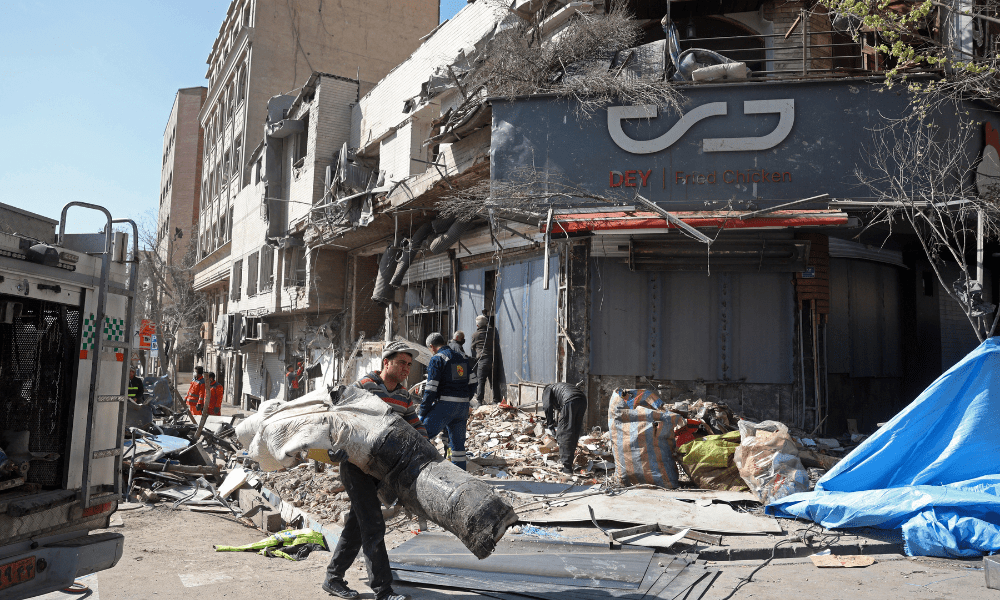 Pessoas inspecionam os destroços de um prédio danificado após ataques aéreos no centro de Teerã, em 4 de março de 2026. A Guarda Revolucionária do Irã afirmou em 4 de março que tinha controle total do Estreito de Ormuz, uma via navegável fundamental para o trânsito global de energia, enquanto Israel lançava uma nova onda de ataques contra a capital iraniana.