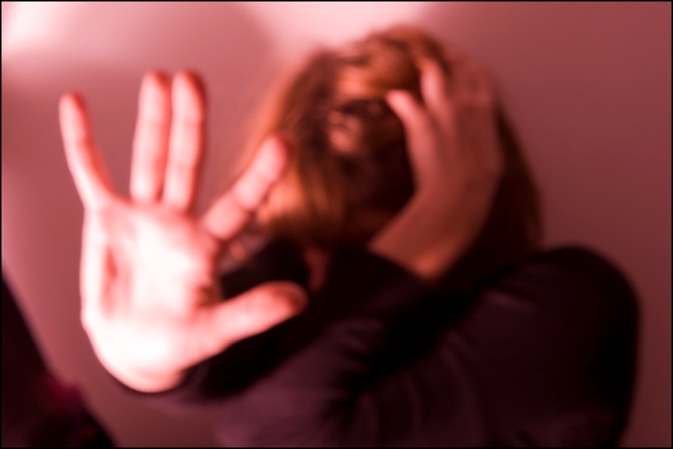 Mulher vítima de violência se encolhe e tenta afastar agressor