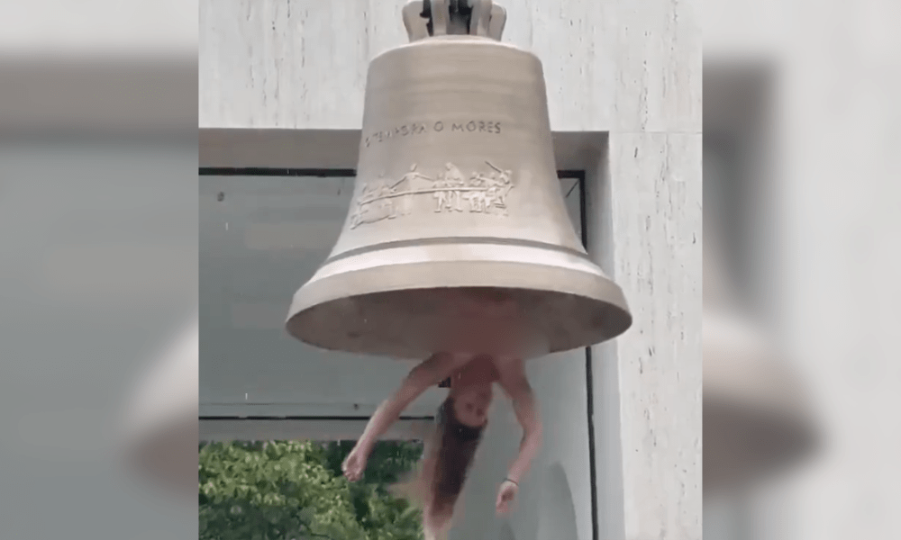Artista performa nua em sino gigante contra crise climática e gera polêmica