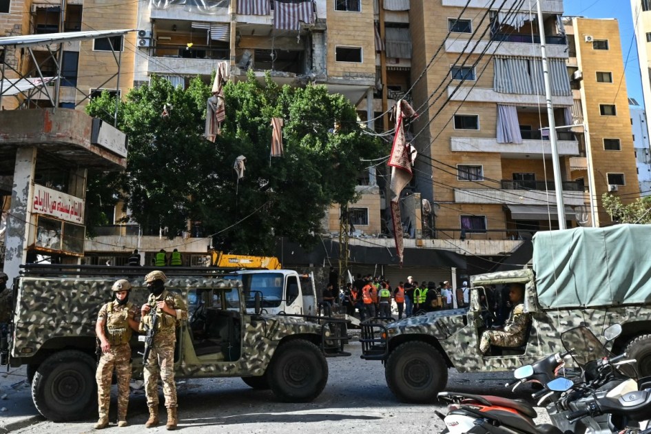 Soldados libaneses montam guarda enquanto equipes de resgate inspecionam os danos no local de um ataque aéreo israelense que atingiu apartamentos em um prédio residencial nos subúrbios ao sul de Beirute em 7 de junho de 2026