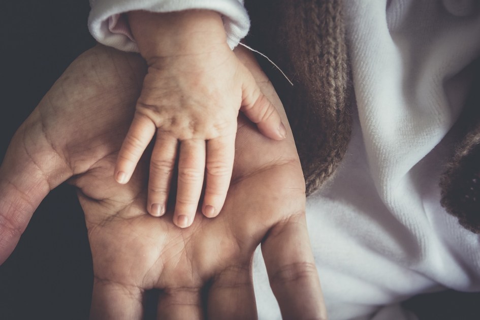 Mão de bebê sobre mão de adulto