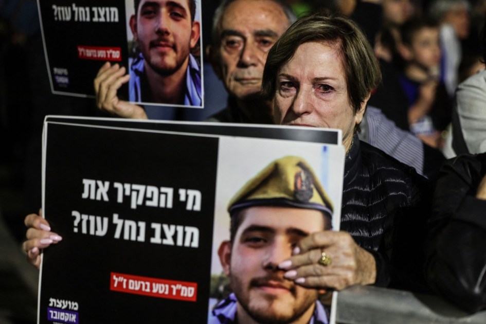 Manifestantes seguram retratos de um soldado que morreu durante o ataque do Hamas a Israel em 7 de outubro de 2023, enquanto participam de uma demonstração organizada por ativistas da esquerda israelense contra a guerra em andamento com o Irã e o Líbano e contra o governo israelense, na Praça HaBima, em Tel Aviv, em 18 de abril de 2026