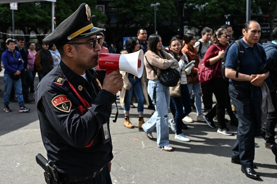 Um membro da Secretaria de Segurança Cidadã usa um megafone para dar instruções a pessoas evacuadas de vários prédios, após uma evacuação preventiva na Cidade do México em 17 de julho de 2026, depois que um terremoto de magnitude 7,3 atingiu o sul do México e partes da América Central. Um terremoto de magnitude 7,3 abalou o sul do México e partes da América Central na sexta-feira, segundo o Serviço Geológico dos EUA (USGS), sem relatos de vítimas até o momento.
