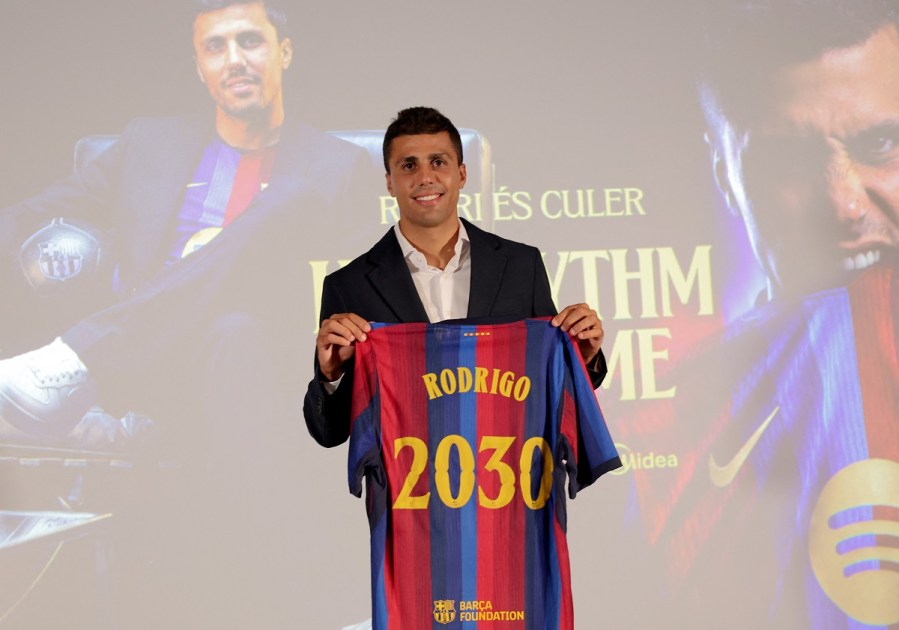 O jogador de futebol espanhol Rodri posa com uma camisa que leva seu nome durante sua apresentação oficial como novo jogador do FC Barcelona, ​​em 18 de agosto de 2026, em Barcelona. O Barcelona anunciou a contratação de Rodri, vindo do Manchester City, com vínculo até 2030, informou a AFP em 18 de agosto de 2026. (Foto de Lluis GENE / AFP)