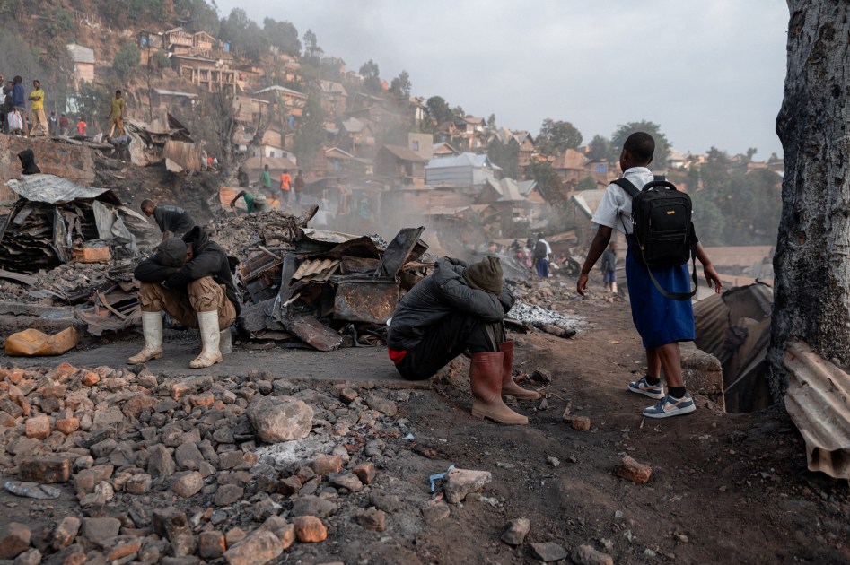 Crianças uniformizadas caminham para a escola passando por casas queimadas, um dia após um incêndio mortal em Cimpunda, na comuna de Kadutu, em Bukavu, em 11 de setembro de 2026.